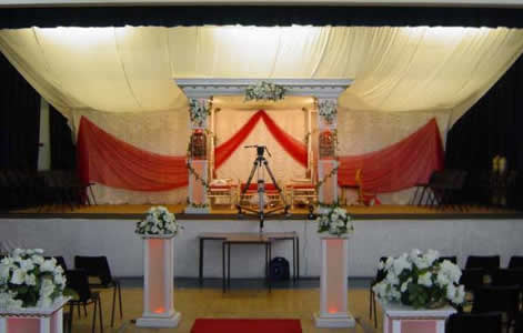 roman mandap with drape and red lights